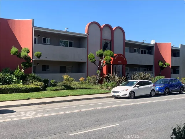 a front view of a house with a garden and parking space