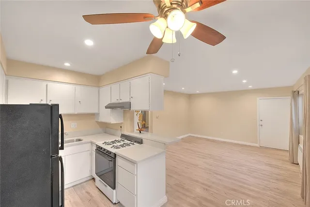 a kitchen with stainless steel appliances granite countertop a refrigerator a stove and a sink