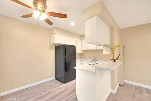 a room with a refrigerator and ceiling fan