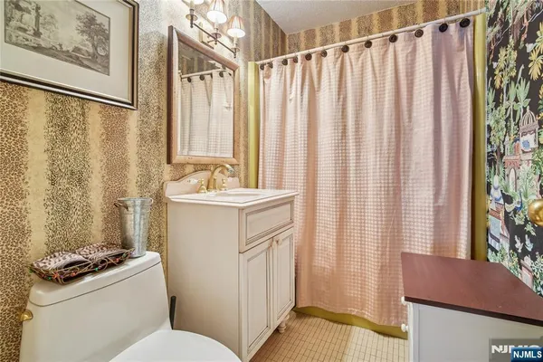 a bathroom with a sink a toilet and shower curtain
