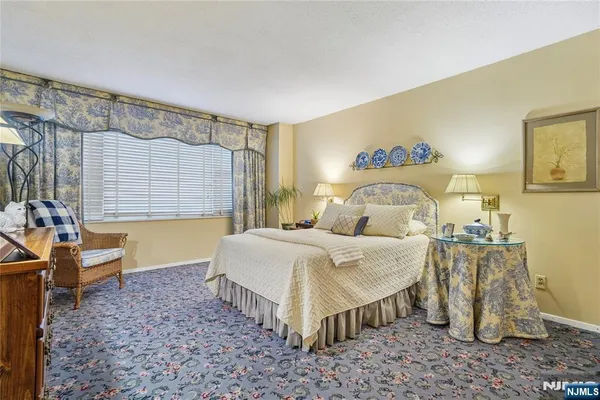 a spacious bedroom with a bed and a chandelier