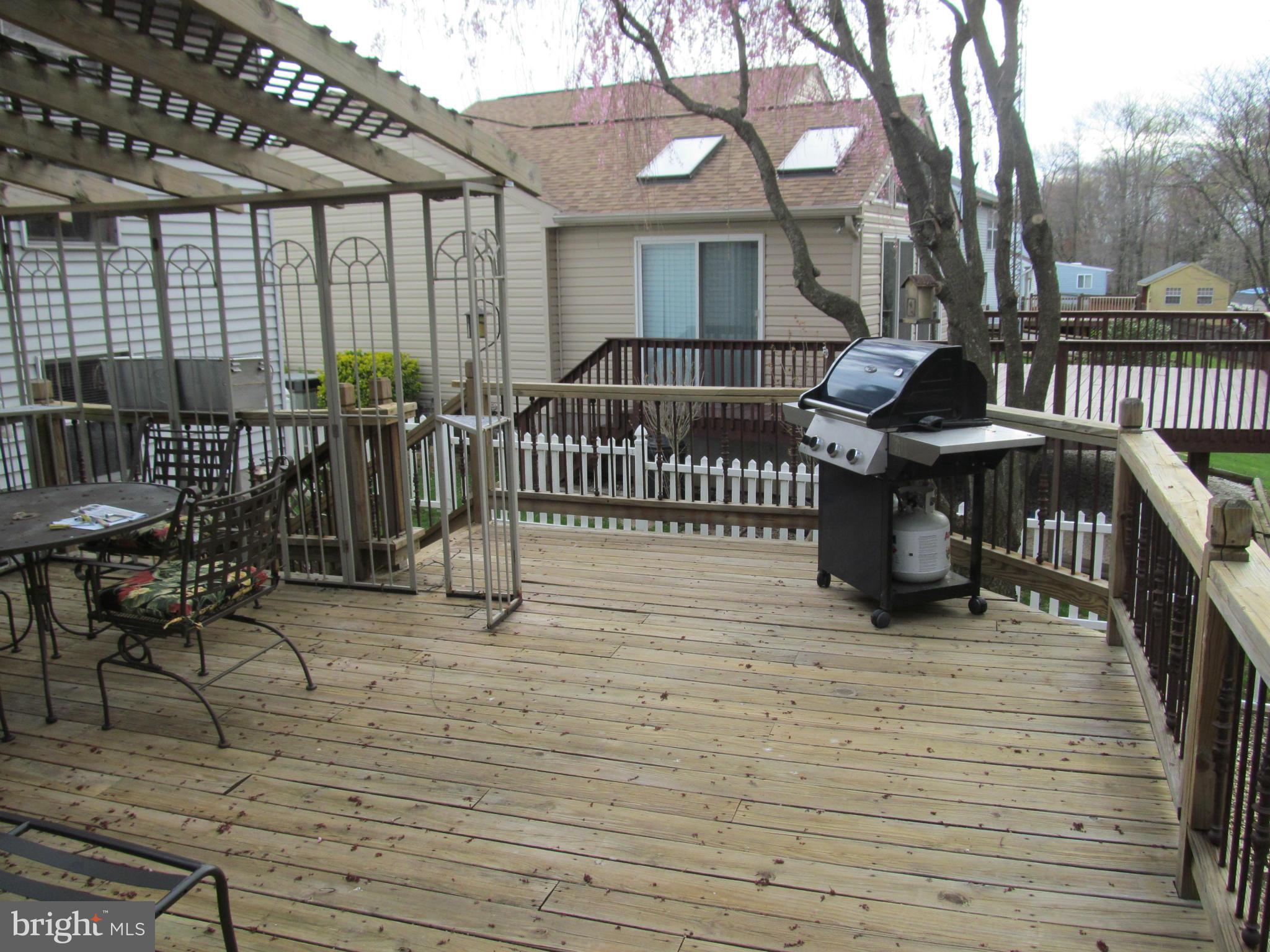 54 Yew Road Baltimore, MD 21221 - Photo 25 of 28 a view of a roof deck with table and chairs and wooden floor