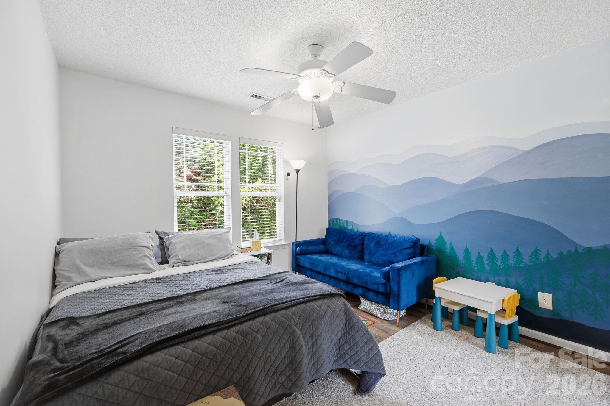 51 Sunview Circle Arden, NC 28704 - Photo 15 of 31 a bedroom with a bed and a chandelier