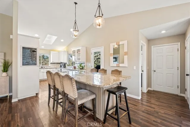 a kitchen with a sink dishwasher a refrigerator and cabinets with wooden floor