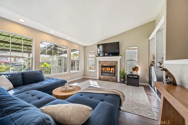 a living room with furniture a flat screen tv and a fireplace