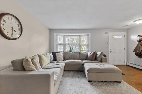a living room with furniture a clock and a window