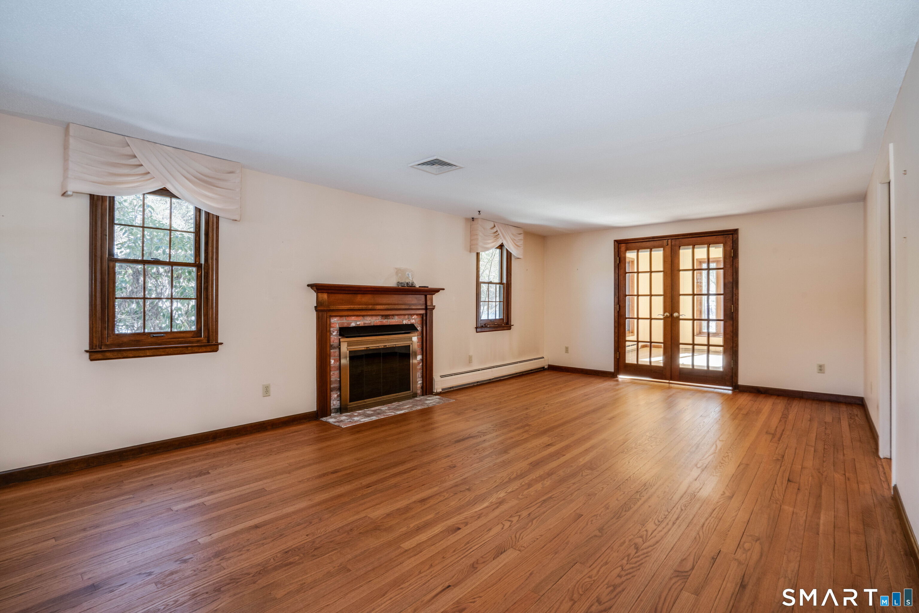 29 Long View Drive Simsbury, CT 06070 - Photo 6 of 41 an empty room with wooden floor fireplace and windows