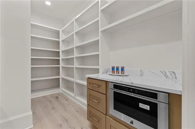 a view of empty room with wooden floor and ceiling fan