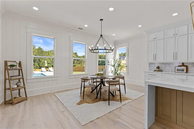 an empty room with wooden floor chandelier fan and windows