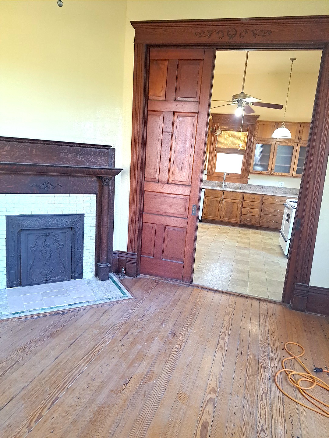 105 Davis Drive Thorndale, TX 76577 - Photo 15 of 21 Rich wood trim frames a classic fireplace and sliding pocket doors opening to the kitchen.