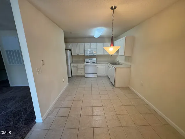 a kitchen with white cabinets sink and white appliances