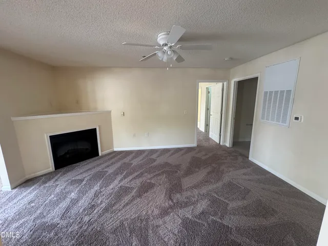 an empty room with windows and fireplace