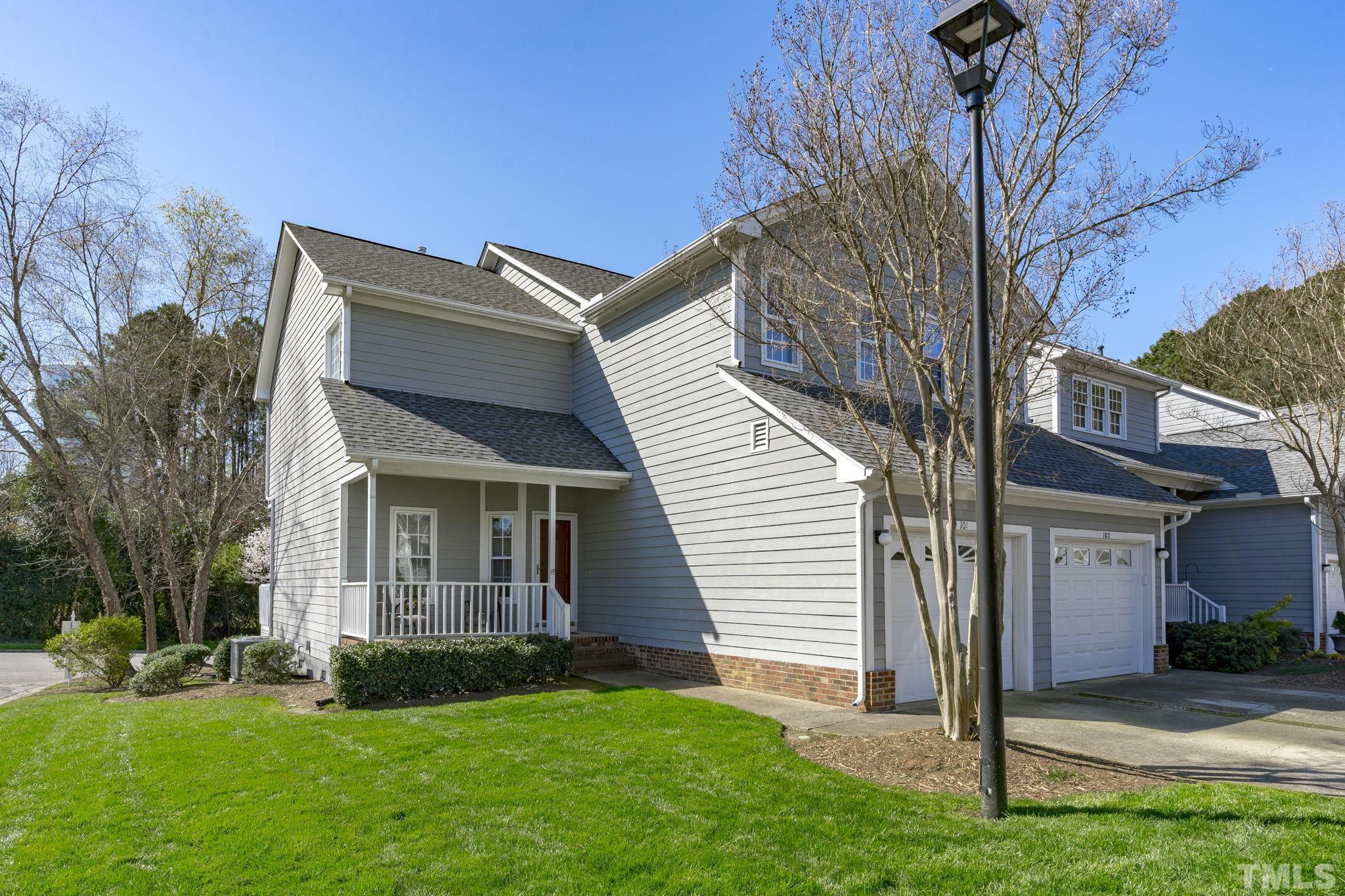 8201 Hempshire Place, Unit 101 Raleigh, NC 27613 - Photo 1 of 15 a front view of a house with a garden