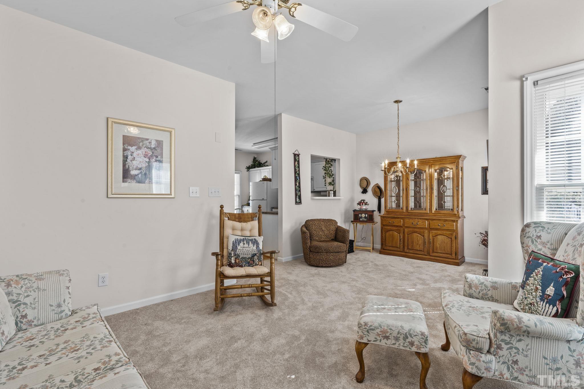 8201 Hempshire Place, Unit 101 Raleigh, NC 27613 - Photo 4 of 15 a living room with furniture and a chandelier