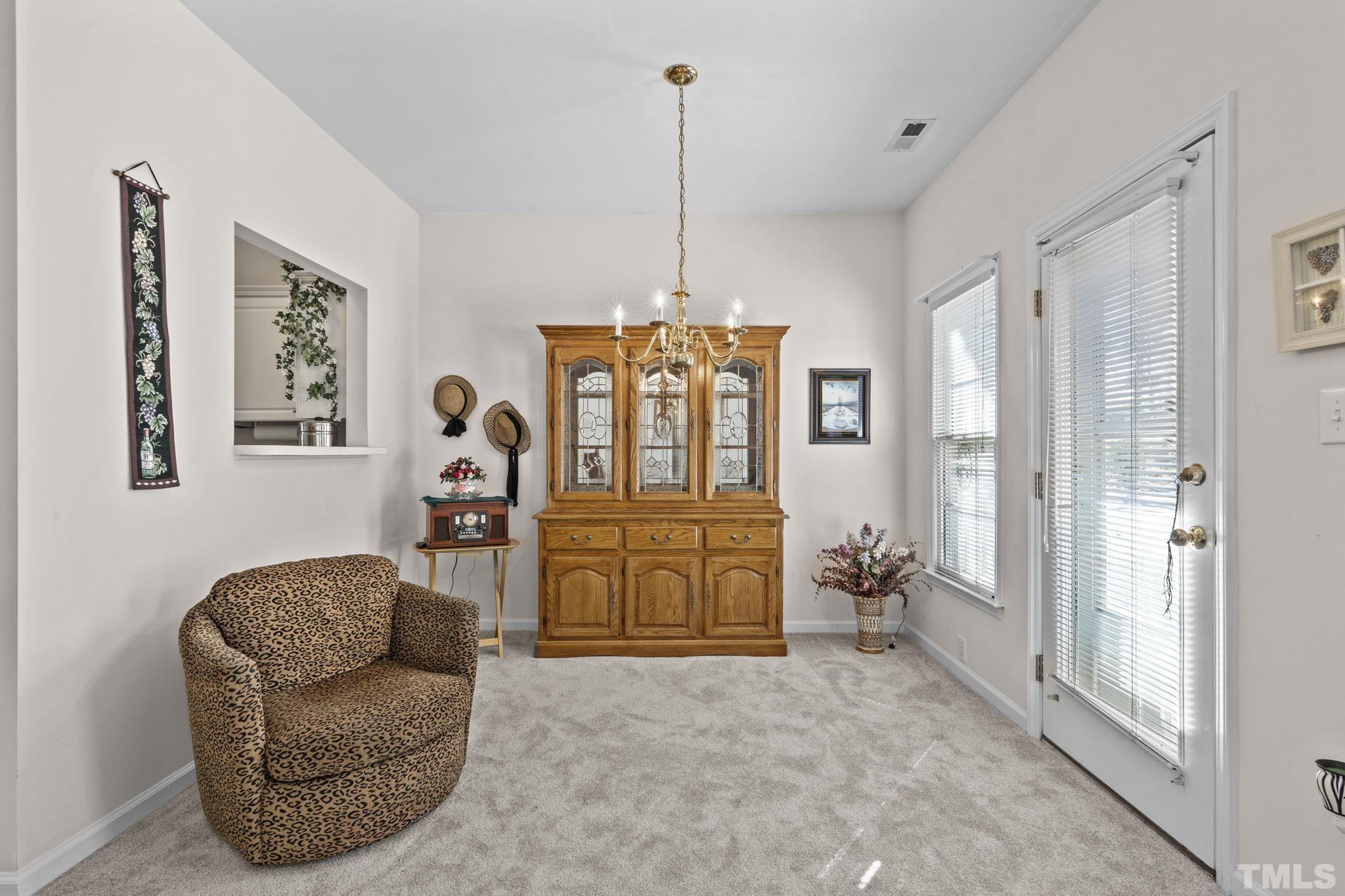 8201 Hempshire Place, Unit 101 Raleigh, NC 27613 - Photo 6 of 15 a living room with furniture windows and a chandelier