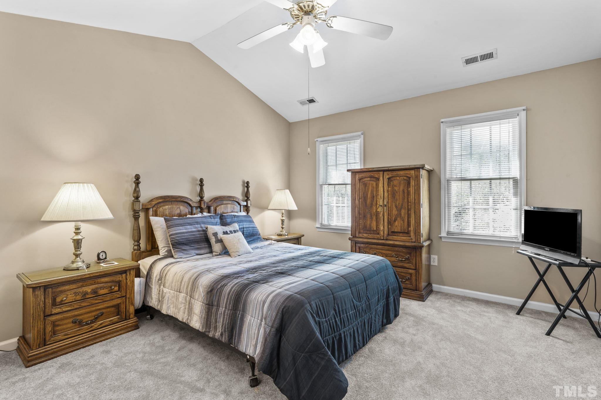 8201 Hempshire Place, Unit 101 Raleigh, NC 27613 - Photo 8 of 15 a bedroom with a bed and a chandelier