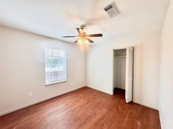 a view of an empty room with wooden floor