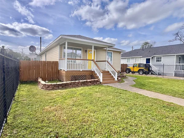 a view of a house with a big yard and a large tree