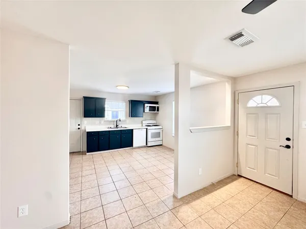 a large white kitchen with a sink and white cabinets