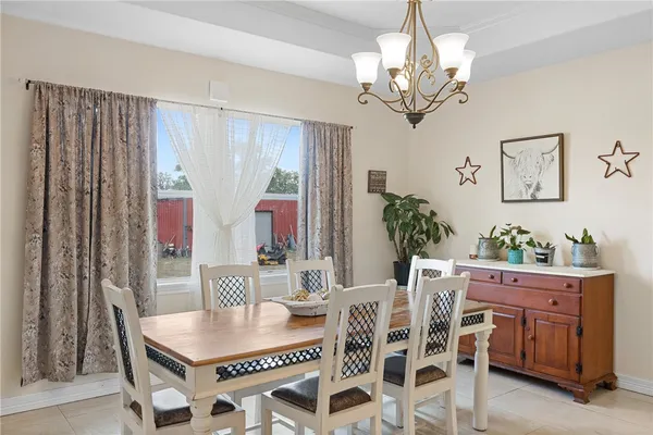 a dining room with furniture a chandelier and window