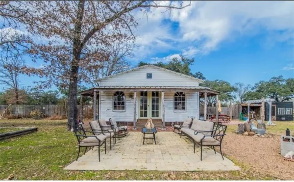 a view of a house with backyard and sitting area