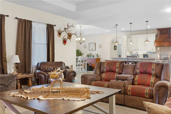 a living room with furniture kitchen view and a large window