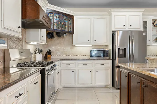 a kitchen with stainless steel appliances granite countertop a refrigerator and a stove