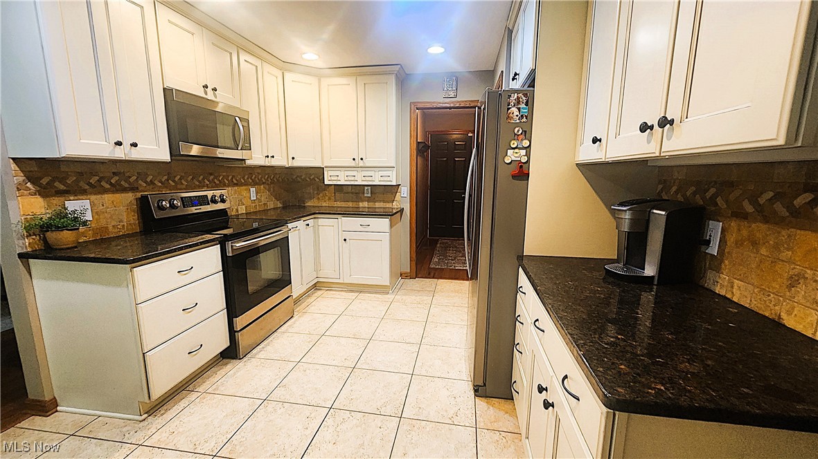 8329 Seasons Road Streetsboro, OH 44241 - Photo 5 of 35 Kitchen featuring tasteful backsplash, light tile patterned flooring, white cabinets, and stainless steel appliances