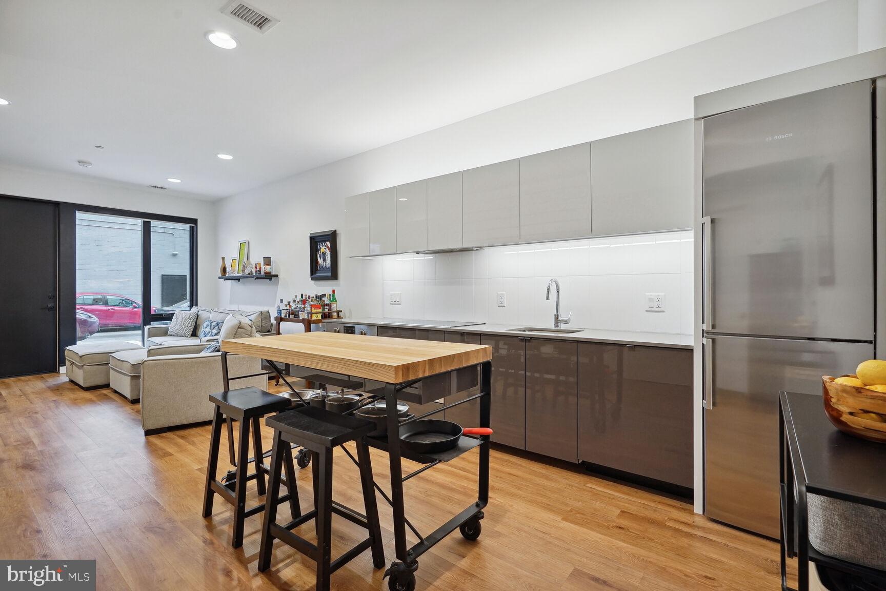 a kitchen with stainless steel appliances granite countertop a table chairs sink refrigerator and microwave