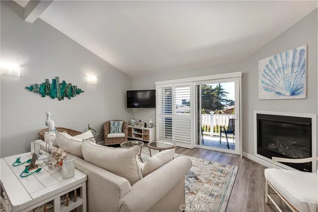 a view of a dining room with furniture a fireplace and wooden floor