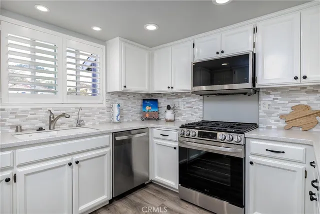 a kitchen with appliances a sink and cabinets