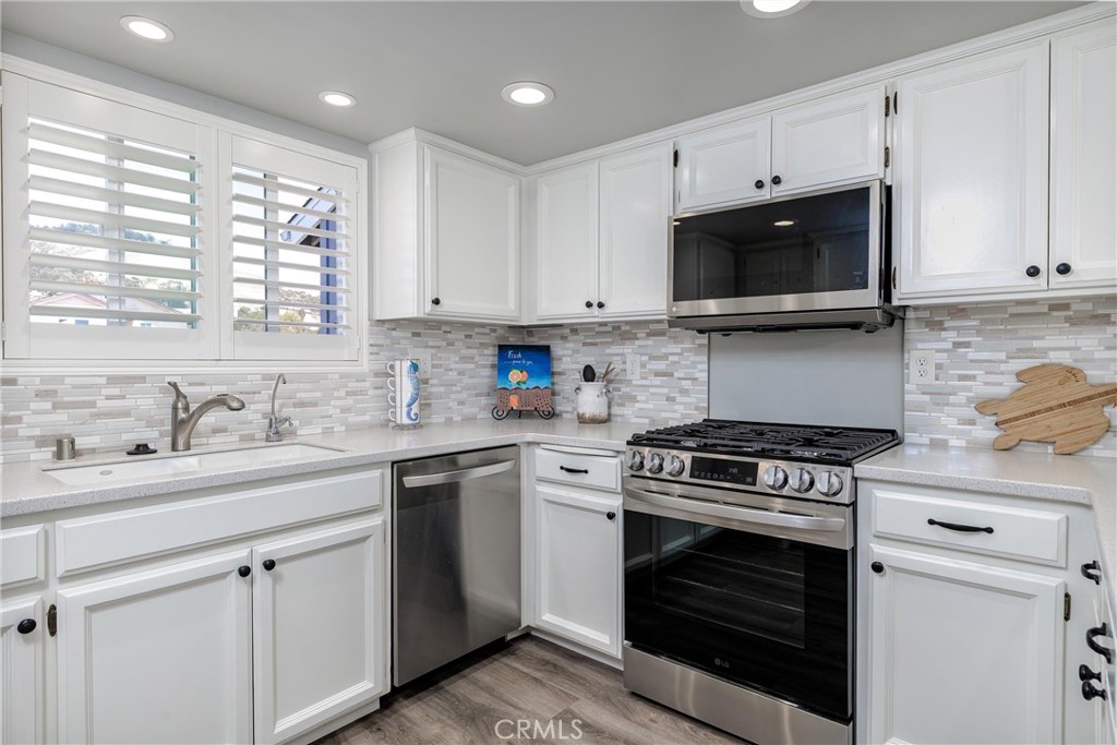 309 Sequoia Street, Unit 3 Morro Bay, CA 93442 - Photo 6 of 20 a kitchen with cabinets stainless steel appliances a sink and a window