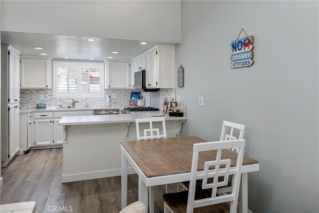 309 Sequoia Street, Unit 3 Morro Bay, CA 93442 - Photo 9 of 20 a kitchen with kitchen island a stove and a refrigerator with wooden floor