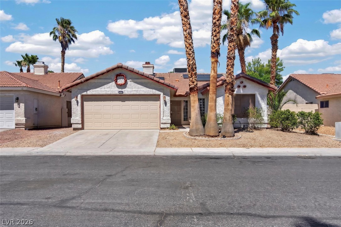 2609 Shakespeare Road Las Vegas, NV 89108 - Photo 2 of 41 A well-maintained stucco home with a tile roof and mature palm trees.