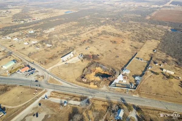 an aerial view of house with yard and mountain view in back