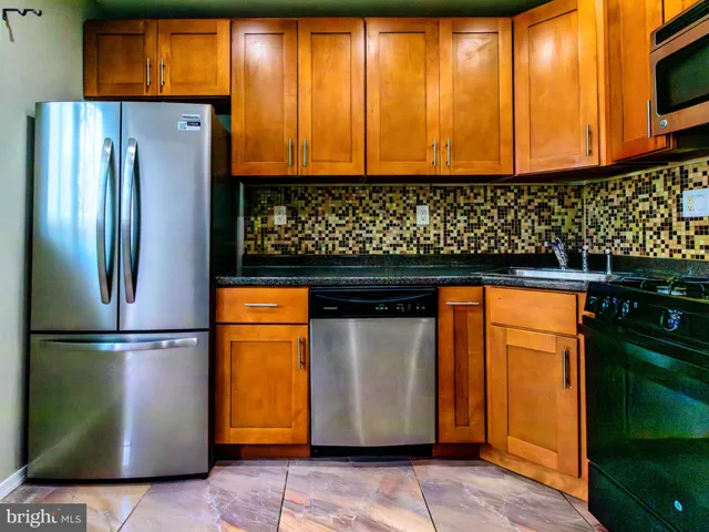 a kitchen with stainless steel appliances granite countertop a refrigerator and a sink