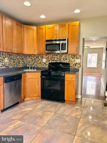 a kitchen with stainless steel appliances granite countertop a stove and a sink