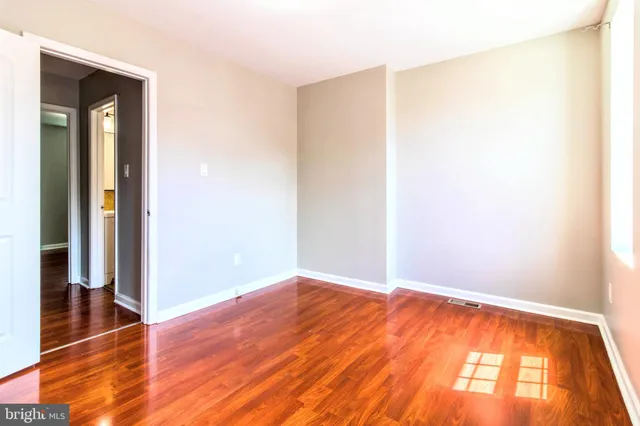 a view of empty room with wooden floor