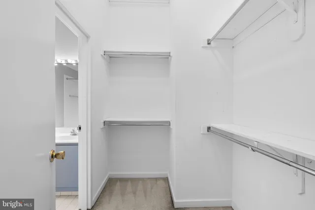 a view of walk in closet with empty racks