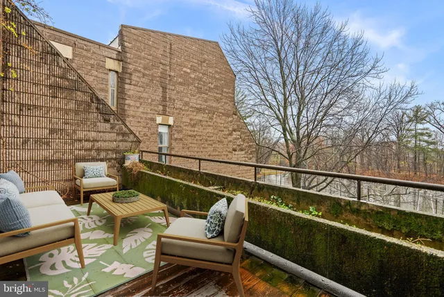 a view of a balcony with wooden floor and outdoor seating