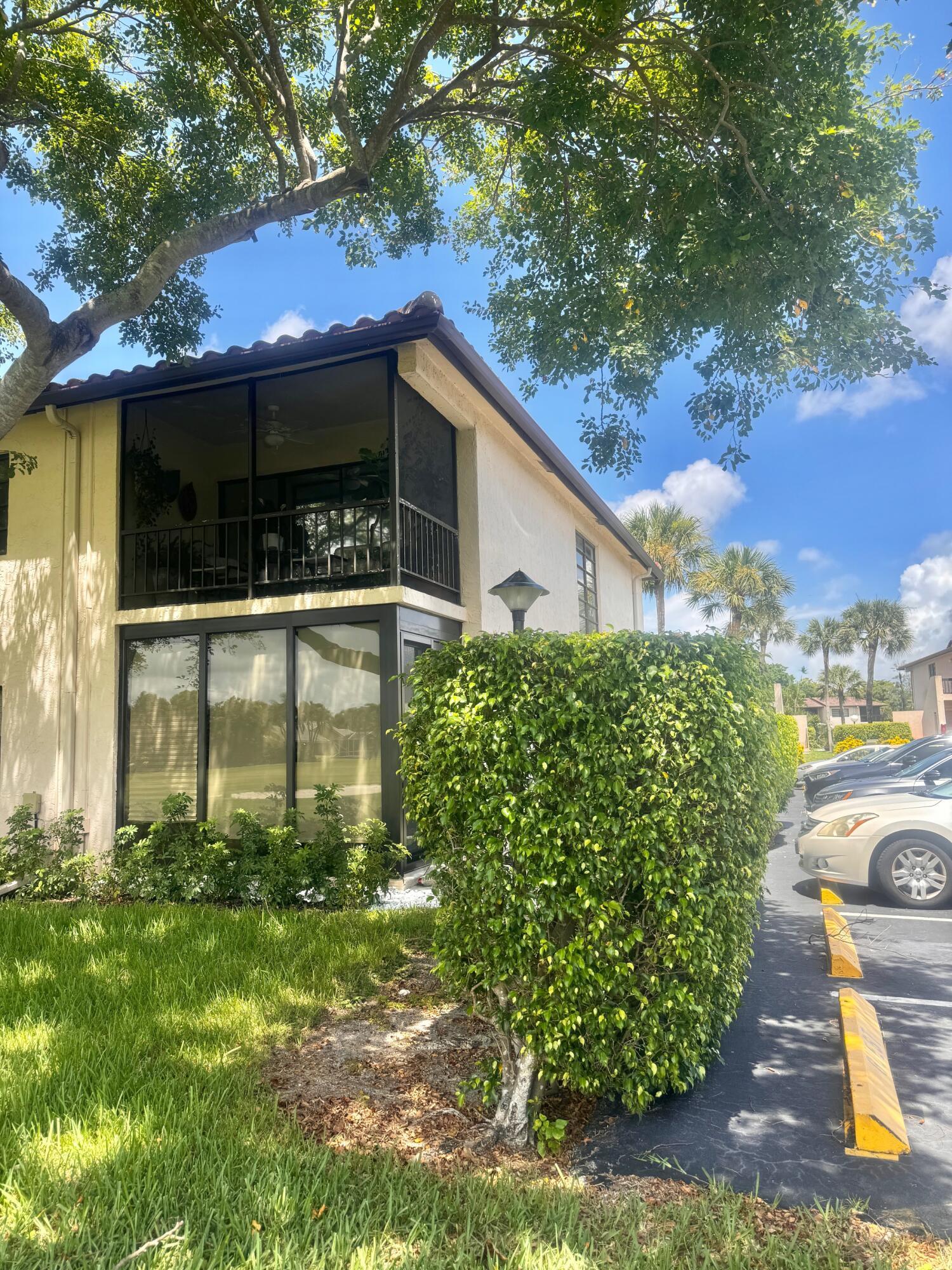 21411 Juego Circle, Unit 32B Boca Raton, FL 33433 - Photo 2 of 7 a front view of a house with garden