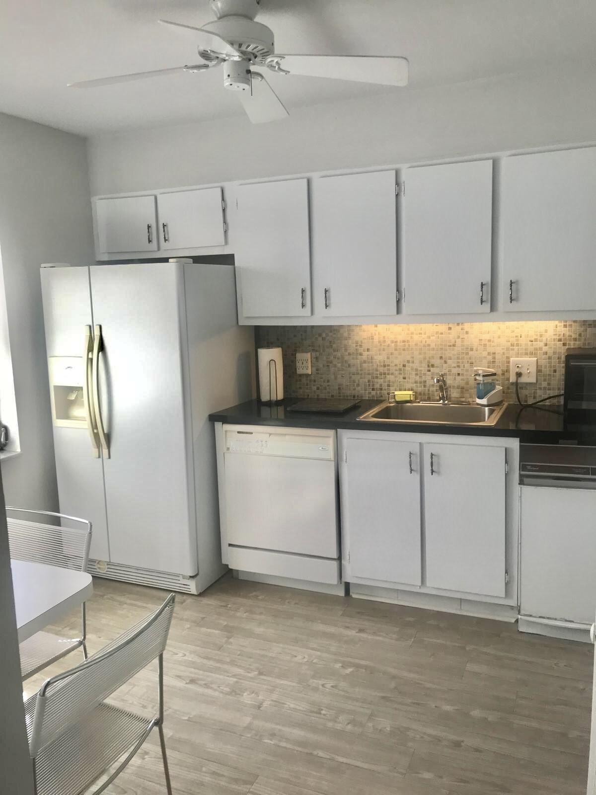 21411 Juego Circle, Unit 32B Boca Raton, FL 33433 - Photo 6 of 7 a kitchen with stainless steel appliances granite countertop a refrigerator a sink and white cabinets
