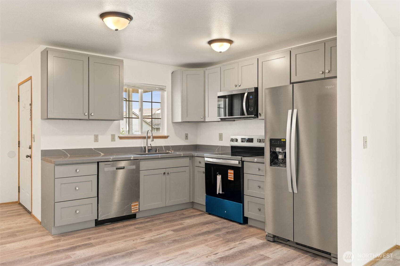 4021 167th Street Northeast, Unit A Arlington, WA 98223 - Photo 4 of 23 a kitchen with granite countertop a refrigerator stove top oven and sink