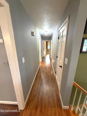a view of a hallway with wooden floor and staircase