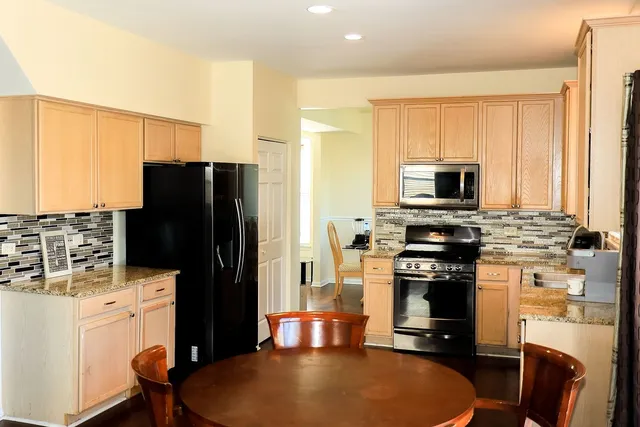 a kitchen with stainless steel appliances granite countertop a refrigerator stove and sink
