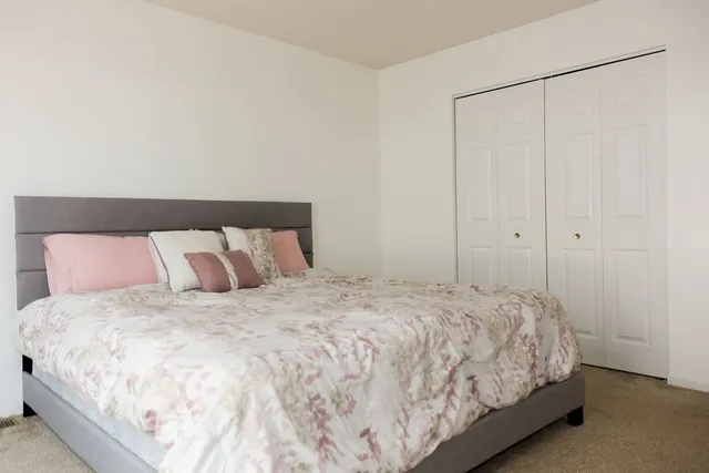 a large bed sitting in a bedroom next to a cabinet