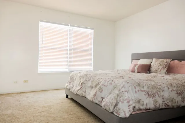 a bed sitting in a bedroom next to a window