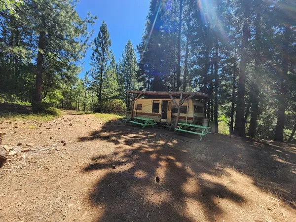 a backyard of a house with a fire pit and trees