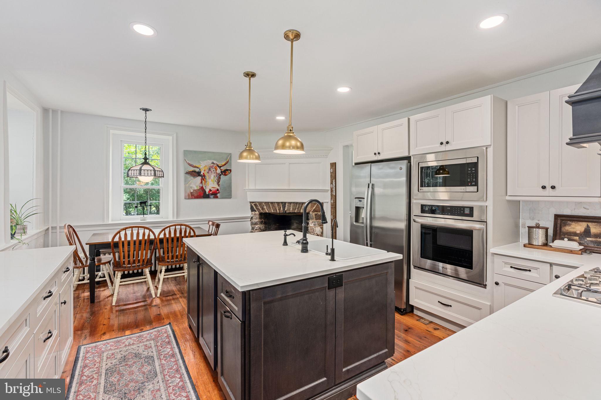 137 Callowhill Road Chalfont, PA 18914 - Photo 19 of 59 a open kitchen with stainless steel appliances granite countertop a stove top oven a sink dishwasher a dining table and chairs with wooden floor