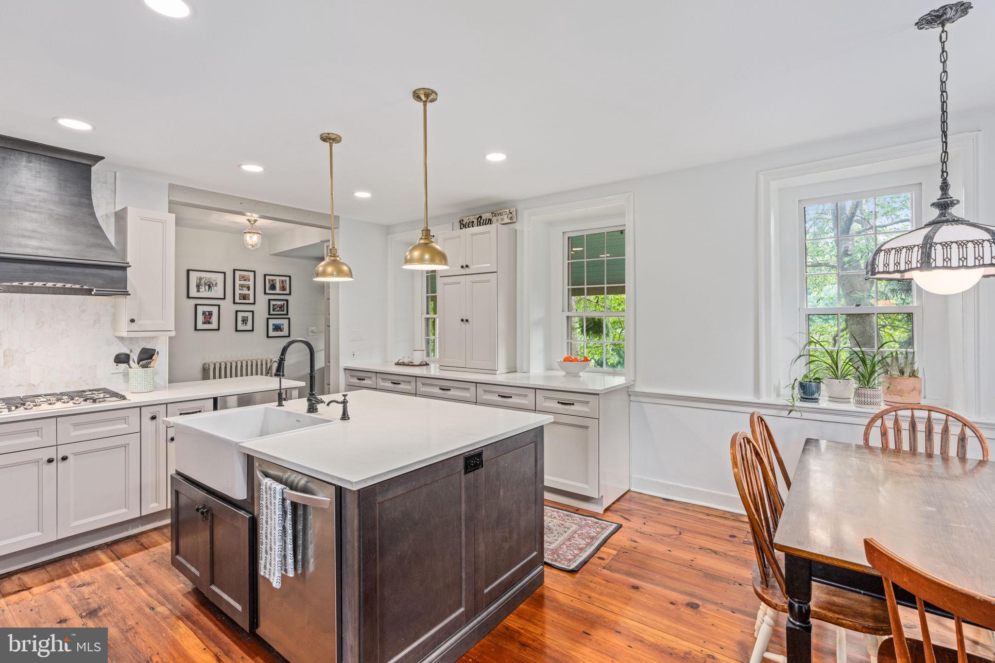 137 Callowhill Road Chalfont, PA 18914 - Photo 22 of 59 a kitchen with a stove a sink a kitchen island with chairs and wooden floor